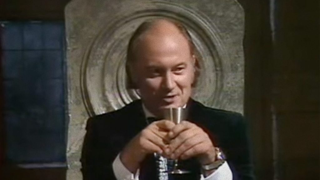 Hendrick sits on his stone chair and drinks sinisterly from a goblet.